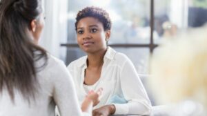 Young African-American woman speaking to another woman