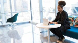 Black woman working on tablet with keyboard in office