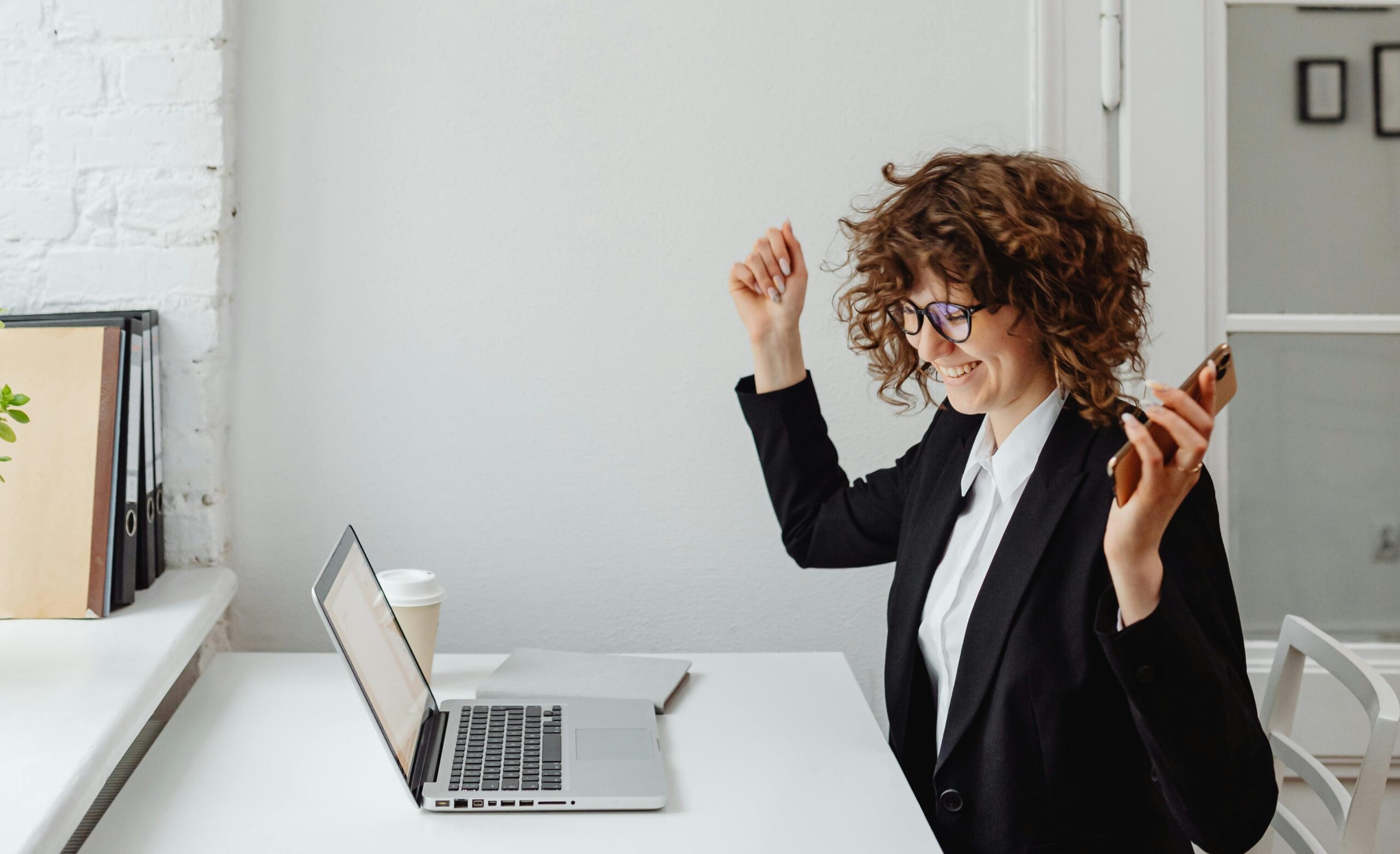 woman feeling accomplished in front of a laptop
